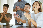 Group of joyful diverse businesspeople clapping hands in support during a meeting together at work. Happy business professionals giving a coworker an applause in a workshop