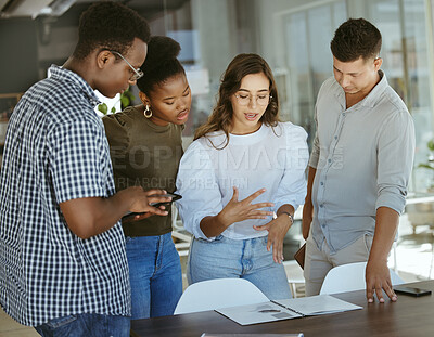 Buy stock photo Group of focused businesspeople standing and talking together in an office. Hispanic businesswoman doing a presentation on a report to her colleagues in a meeting