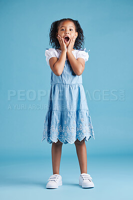 Buy stock photo Adorable hispanic little girl with hands on face and mouth open being surprised and shocked showing true astonished reaction against a blue studio background