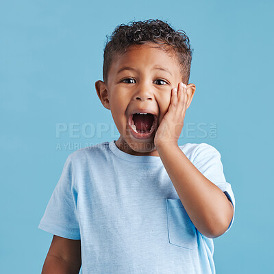 Buy stock photo Cute hispanic little boy with hand on face and mouth open being surprised and shocked showing true astonished reaction against a blue studio background