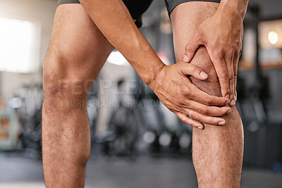Buy stock photo Closeup of one caucasian man holding his sore knee while exercising in a gym. Male athlete suffering with painful leg injury from fractured joint and inflamed muscles during workout. Struggling with stiff body cramps causing discomfort and strain