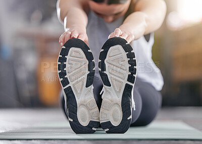 Buy stock photo Closeup of one active caucasian woman touching her feet and stretching legs for warmup to prevent injury while exercising in a gym. Bottom sole of shoes of female athlete preparing for training workout in a fitness centre