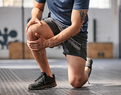 Buy stock photo Closeup of one caucasian man holding his sore knee while exercising in a gym. Male athlete suffering with painful leg injury from fractured joint and inflamed muscles during workout. Struggling with stiff body cramps causing discomfort and strain