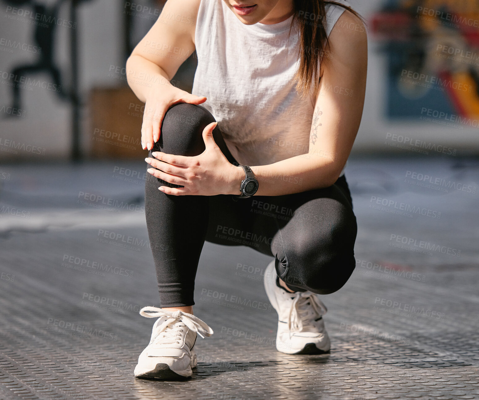 Buy stock photo Closeup of one caucasian woman holding her sore knee while exercising in a gym. Female athlete suffering with painful leg injury from fractured joint and inflamed muscles during workout. Struggling with stiff body cramps causing discomfort and strain