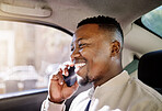Black businessman travelling alone in a taxi while talking on a call using his wireless smartphone device in the morning on his way to work in the city