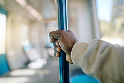 Buy stock photo Black businessman travelling alone and holding on to a pole in a carriage on a train while travelling to the city