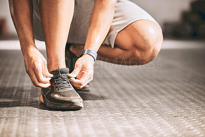 Buy stock photo Hands of a fit man tying laces. Bodybuilder tying his shoe laces. Athletic man getting ready to workout. Fit man tying his sneaker laces. Trainer tying his laces cropped.