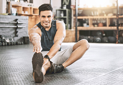Buy stock photo Portrait of strong trainer stretching. Young athlete sitting on the floor to warmup. Hispanic bodybuilder stretching his leg. Happy, strong fitness man stretching before workout class.