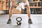 Trainer dusting hands before weight training. Strong athlete using hand powder before lifting a kettlebell. Strong athlete using chalk before lifting heavy weights in the gym. Powder before weights