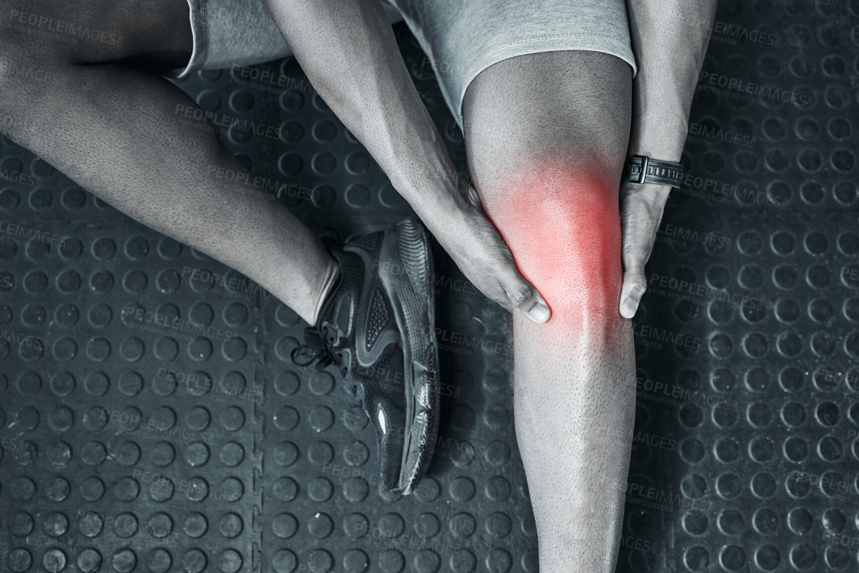 Buy stock photo Joint ache is common in the gym. Trainer touching their knee in pain from above. The knee joint is prone to injury. Closeup of athlete in pain at the gym. CGI red spot of pain on trainers knee