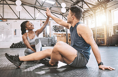 Buy stock photo Trainer giving his client a high five after a workout. Young friends working out together. Friends motivate each other in the gym. Sporty, excited friends exercise together in the gym