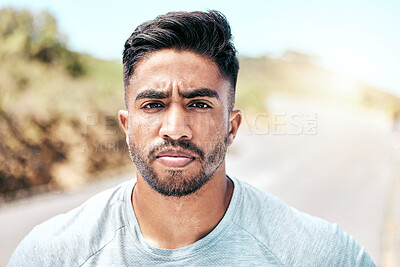 Buy stock photo Portrait athletic young mixed race man looking serious while standing outside. Handsome hispanic male looking focused and determined while exercising, working out and getting fit outdoors
