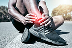 Closeup fit mixed race man holding his ankle in pain while exercising outdoors. Unrecognizable male athlete suffering with a joint injury highlighted by glowing cgi. You can get hurt during a workout