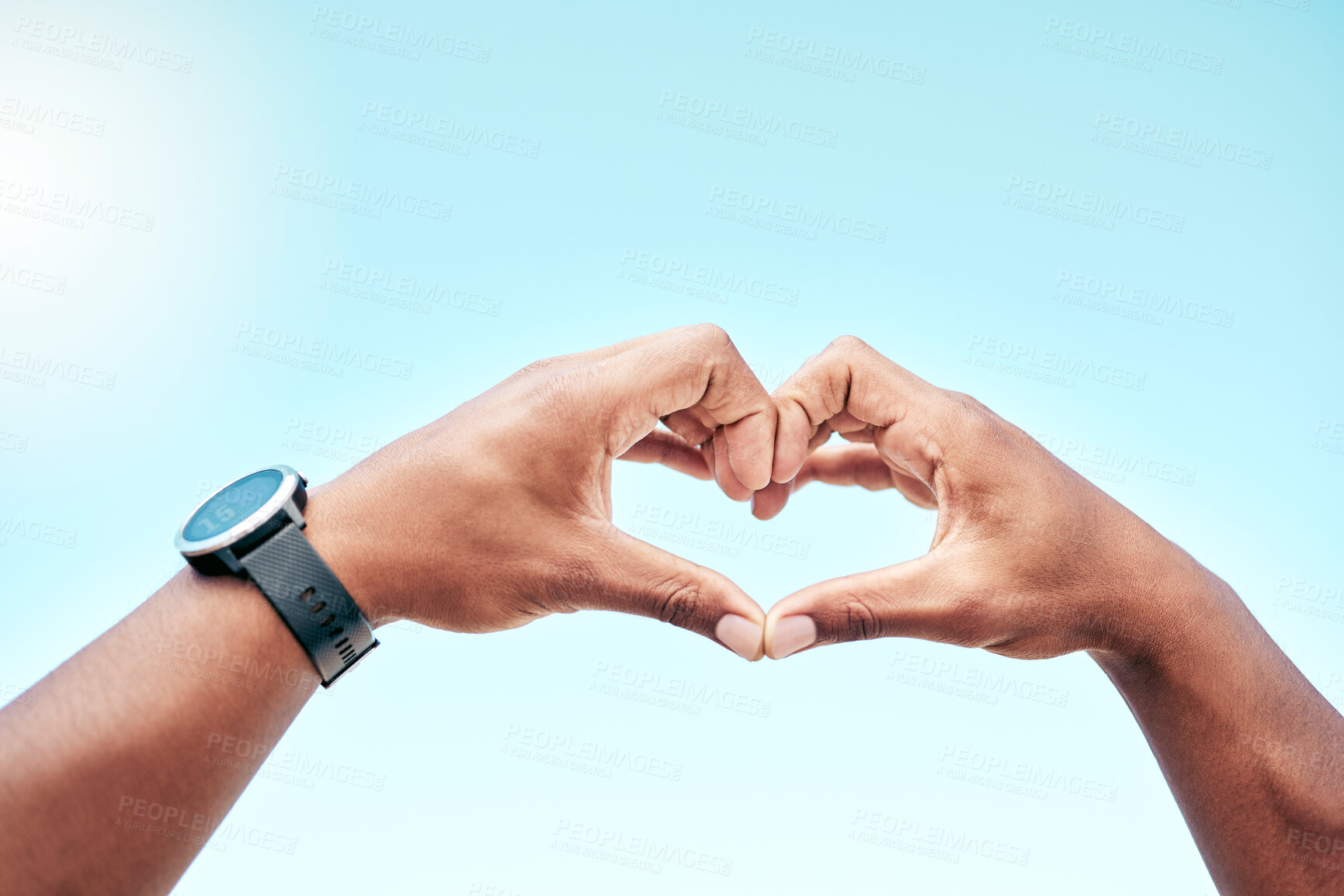 Buy stock photo Closeup hands of a mixed race man making a heart shape against a clear blue sky. Male athlete showing love and appreciation for fitness and health. He's dedicated to living a healthy lifestyle