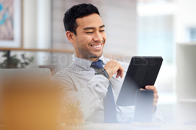 Happy mixed race businessman holding and using a digital tablet sitting in an office at work. Content cheerful hispanic male businessperson smiling while using social media on a digital tablet at work