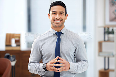 Buy stock photo Young happy mixed race businessman standing alone in an office at work. One confident hispanic businessperson smiling while standing at work