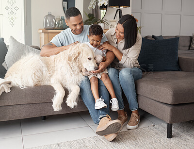 Buy stock photo A happy mixed race family of three relaxing on the sofa with their dog. Loving black family being affectionate with a foster animal. Young couple bonding with their son and rescued puppy at home
