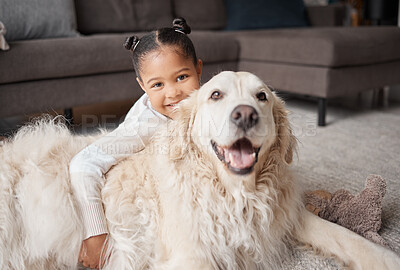 Portrait of a cute little girl holding her emotional support dog while bonding on the lounge floor. A mixed race child looking happy and safe with her puppy at home