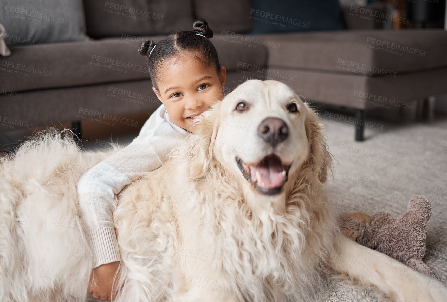 Buy stock photo Portrait of a cute little girl holding her emotional support dog while bonding on the lounge floor. A mixed race child looking happy and safe with her puppy at home