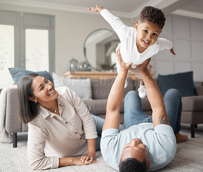 Buy stock photo Happy family, kids and flying games in home on living room floor for fun, quality time and relax. Mom, dad and holding boy child in air for play, happiness and support of parents on carpet in lounge