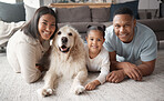 Portrait of a happy mixed race family of three relaxing on the lounge floor with their dog. Loving black family being affectionate with a foster animal. Young couple bonding with their daughter and rescued puppy at home