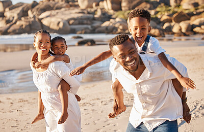 Buy stock photo Happy african american family with two children enjoying vacation by the beach. Playful parents carrying their daughter and son on their backs and giving them a piggyback ride