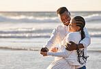 Loving young couple having romantic moment while sharing a dance and spending together at the beach. Happy african american lovers being playful and enjoying time by the sea