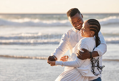 Buy stock photo Loving young couple having romantic moment while sharing a dance and spending together at the beach. Happy african american lovers being playful and enjoying time by the sea