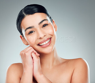Buy stock photo Portrait of a beautiful mixed race woman with smooth soft skin in a studio. Hispanic model with healthy natural glowing skin looking confident against grey copyspace while doing routine skincare