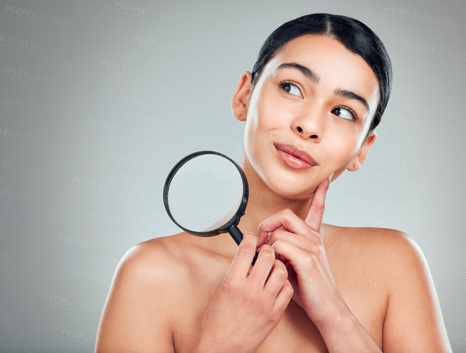 Buy stock photo A beautiful mixed race woman posing with a magnifying glass. Young hispanic obsessed with targeting acne and wrinkles against a grey copyspace background