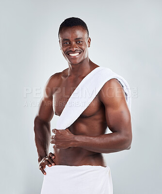 Buy stock photo Portrait of a smiling African American fitness model posing topless in a towel and looking muscular. Happy black male  athlete isolated on grey copyspace in a studio after a shower