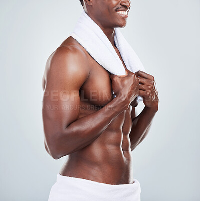 Buy stock photo Closeup of a smiling African American fitness model posing topless in a towel and looking muscular. Happy black male  athlete isolated on grey copyspace in a studio after a shower