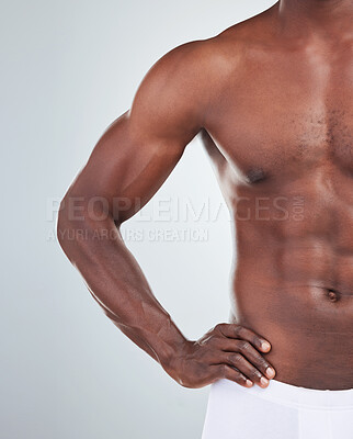 Buy stock photo Closeup of one African American fitness model posing topless in a underwear and looking muscular. Confident black male athlete isolated on grey copyspace in a studio wearing boxers showing his sixpack