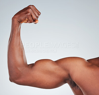 Buy stock photo Closeup of one unrecognizable African American fitness model posing topless in and looking muscular. Confident black male athlete isolated on grey copyspace in a studio flexing his bicep
