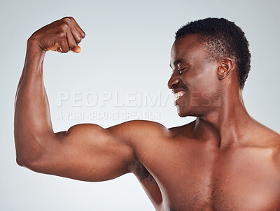 Buy stock photo Closeup of one African American fitness model posing topless in and looking muscular. Confident black male athlete isolated on grey copyspace in a studio flexing his bicep