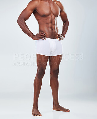 Buy stock photo Closeup of one  African American fitness model posing topless in a underwear and looking muscular. Confident black male athlete isolated on grey copyspace in a studio wearing boxers