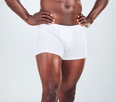 Buy stock photo Closeup of one  African American fitness model posing in a underwear and looking muscular. Confident black male athlete isolated on grey copyspace in a studio wearing boxers with strong, toned legs