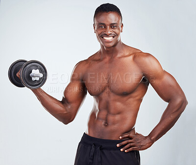 Buy stock photo Portrait of a smiling African American fitness model posing topless while exercising with dumbbells .Happy black male athlete isolated on grey copyspace while weightlifting in a studio