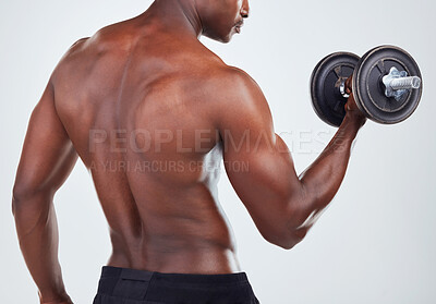 Buy stock photo One young African American fitness model posing topless while exercising with dumbbells .Confident black male athlete isolated on grey copyspace while weightlifting in a studio