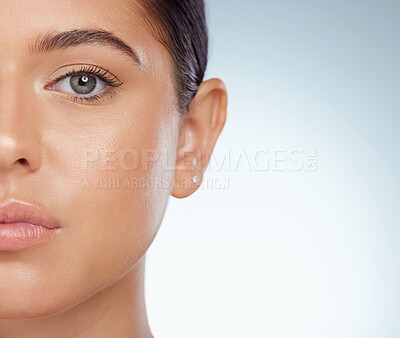 Buy stock photo Closeup half face portrait of beautiful woman with smooth glowing skin and copyspace. Headshot of caucasian model isolated against grey studio background. Young woman with healthy skincare routine
