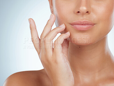 Buy stock photo Closeup of unknown woman with perfect lips touching her face in studio. Caucasian model with smooth glowing skin isolated against grey background and showing manicured hand. Healthy self care routine