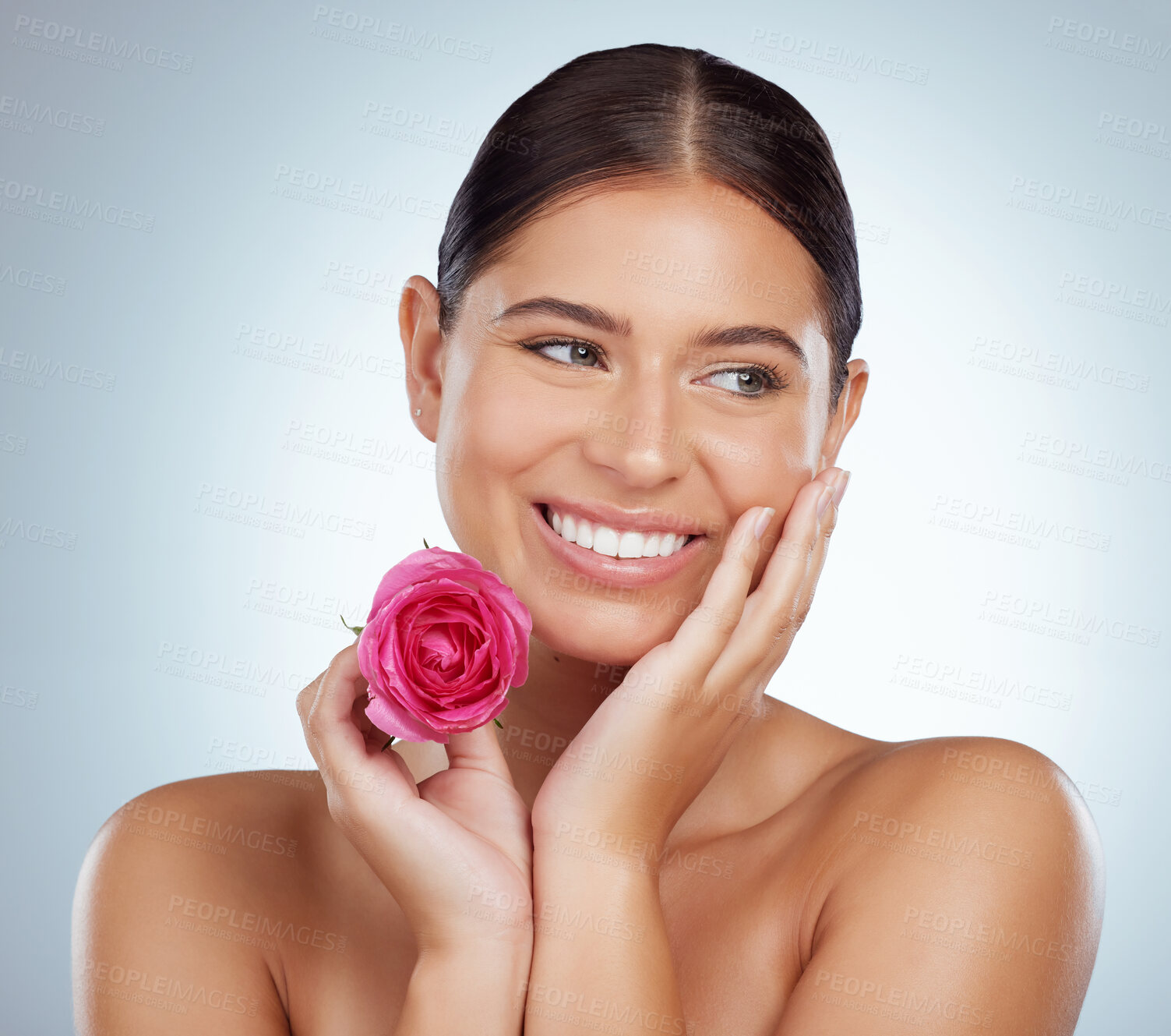 Buy stock photo Smiling beautiful woman holding pink rose while posing topless with copyspace. Caucasian model isolated against grey studio background with smooth glowing skin and delicate healthy skincare routine