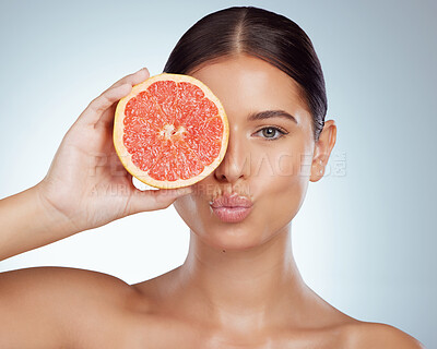 Buy stock photo Face kiss, skincare and woman with grapefruit in studio isolated on white background. Portrait, natural or female model with fruit for vitamin c, nutrition or healthy diet, wellness or cosmetics pout