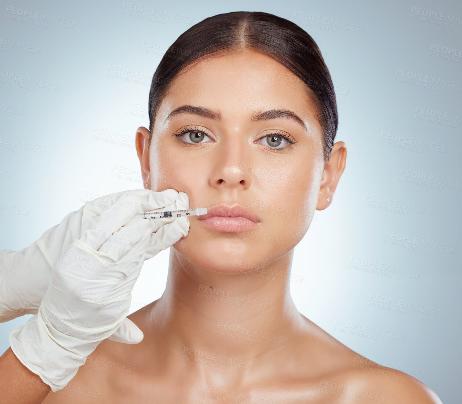 Buy stock photo Portrait of serious woman getting lip fillers or botox. Young caucasian model isolated against grey studio background with copyspace. Dermatologist injecting patient in anti ageing cosmetic procedure