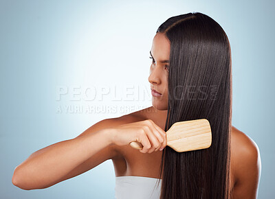 Buy stock photo A beautiful young mixed race woman brushing her healthy strong hair against a grey studio background. Hispanic female grooming her hair