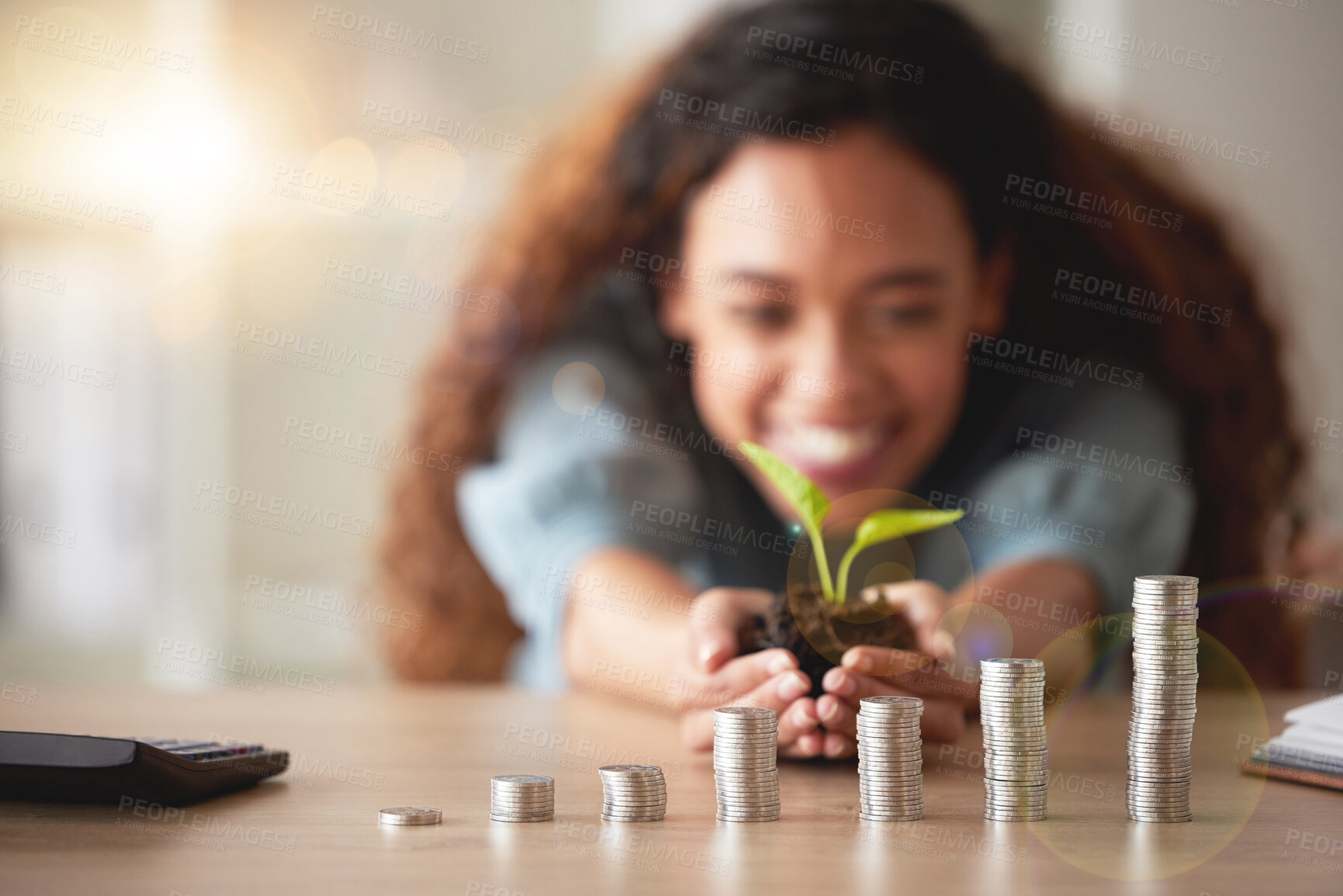 Buy stock photo African American woman holding a growing plant in her hands while counting her savings. Stacks of coins symbolising positive financial growth, goals and a budget. Nurturing her future plans and profit
