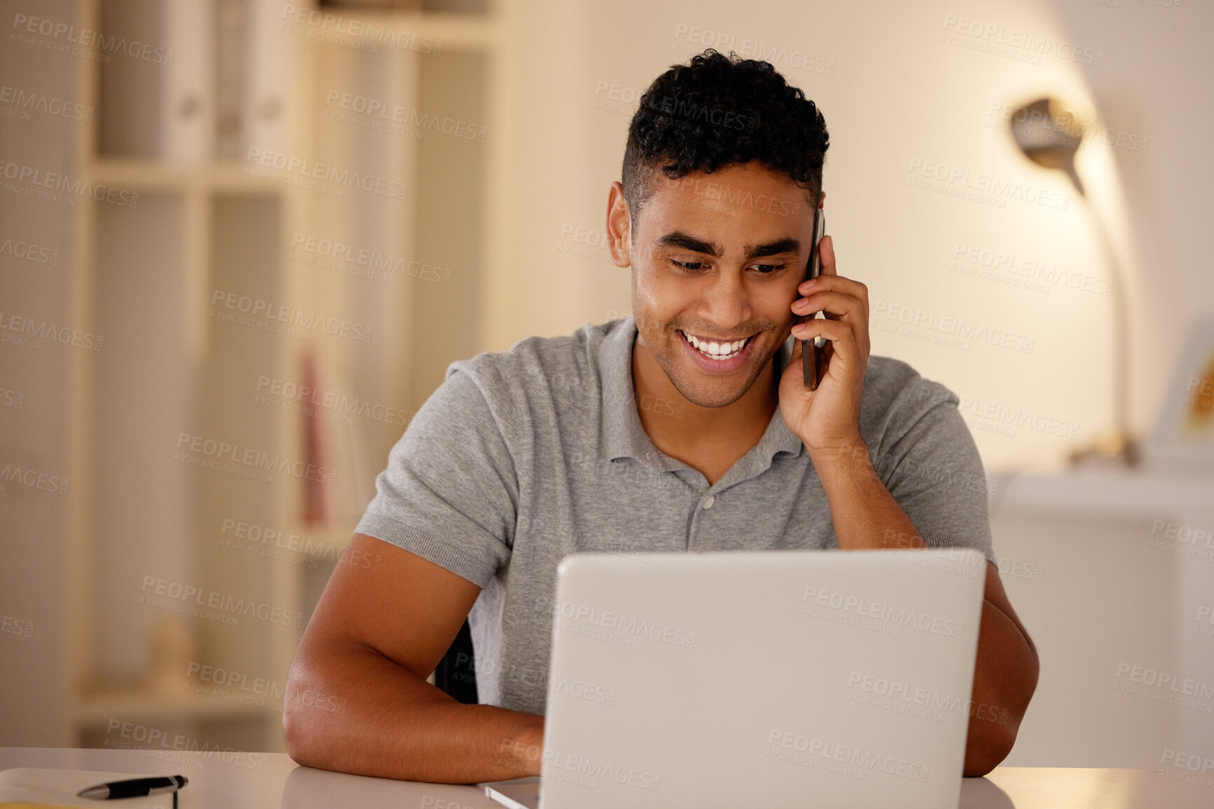 Buy stock photo Man working remotely using a laptop and talking on a cellphone. Businessman working from home. Happy male doing freelance work while on a call. Excited about an investment while working at the office