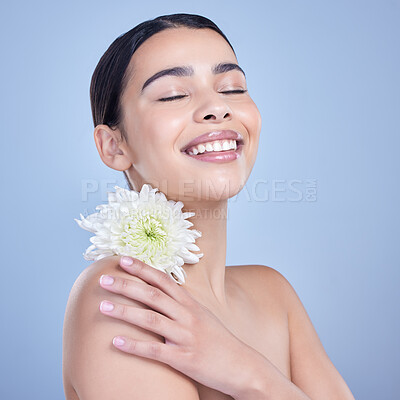 Buy stock photo A beautiful mixed race woman posing with a flower. Young hispanic using an organic skincare treatment against a blue copyspace background