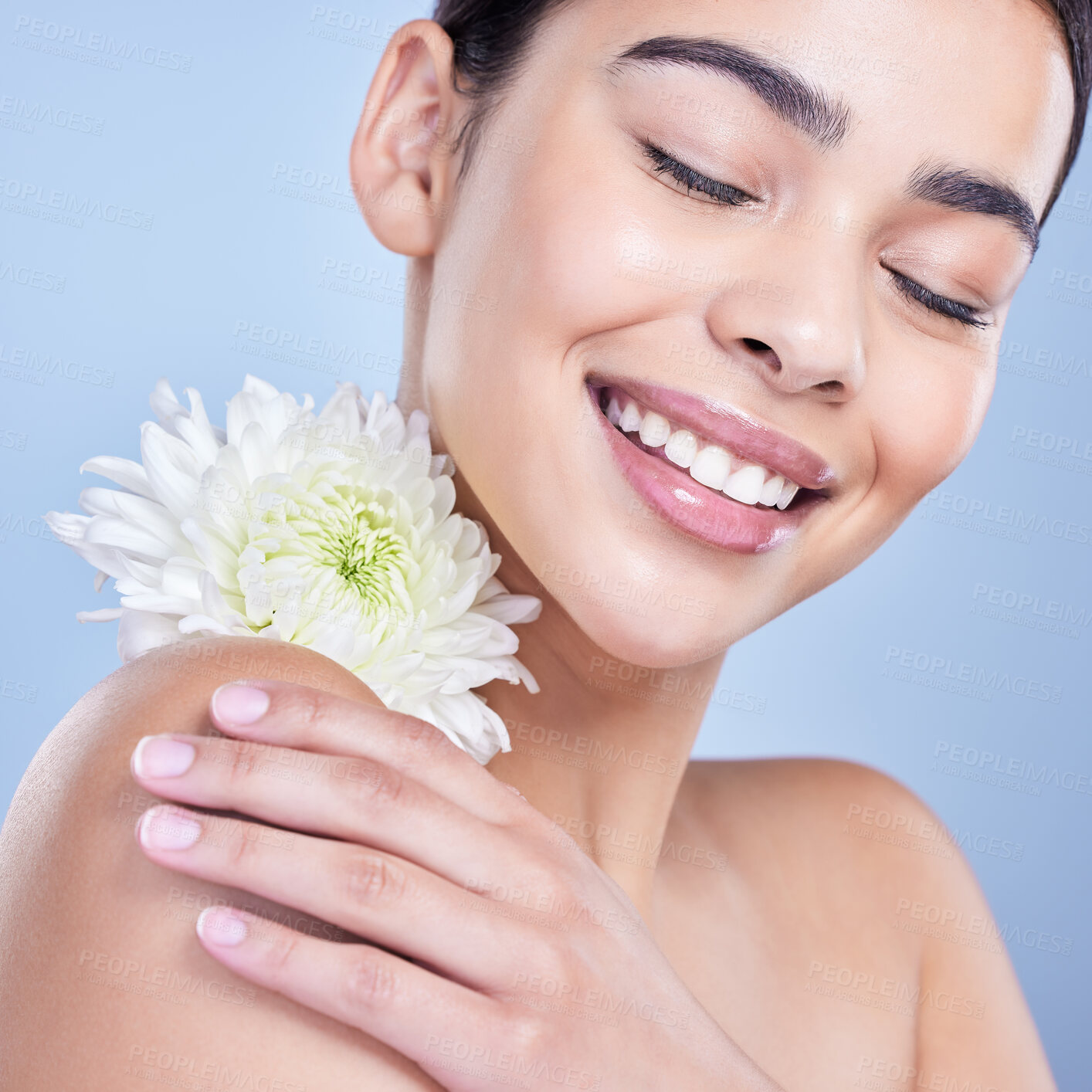 Buy stock photo A beautiful mixed race woman posing with a flower. Young hispanic using an organic skincare treatment against a blue copyspace background