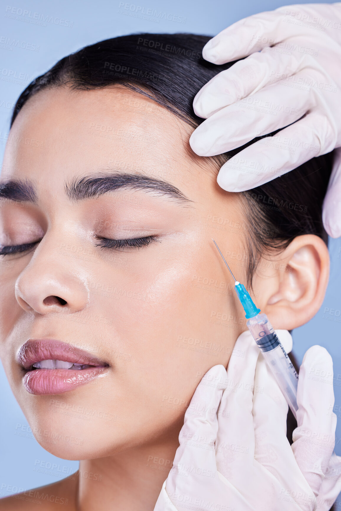 Buy stock photo A gorgeous mixed race woman getting botox filler in her face. Hispanic model getting cosmetic surgery against a blue copyspace background